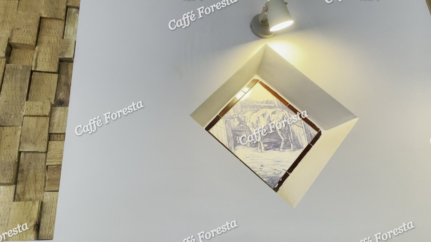 A small diamond-framed print, spotlit on the wall