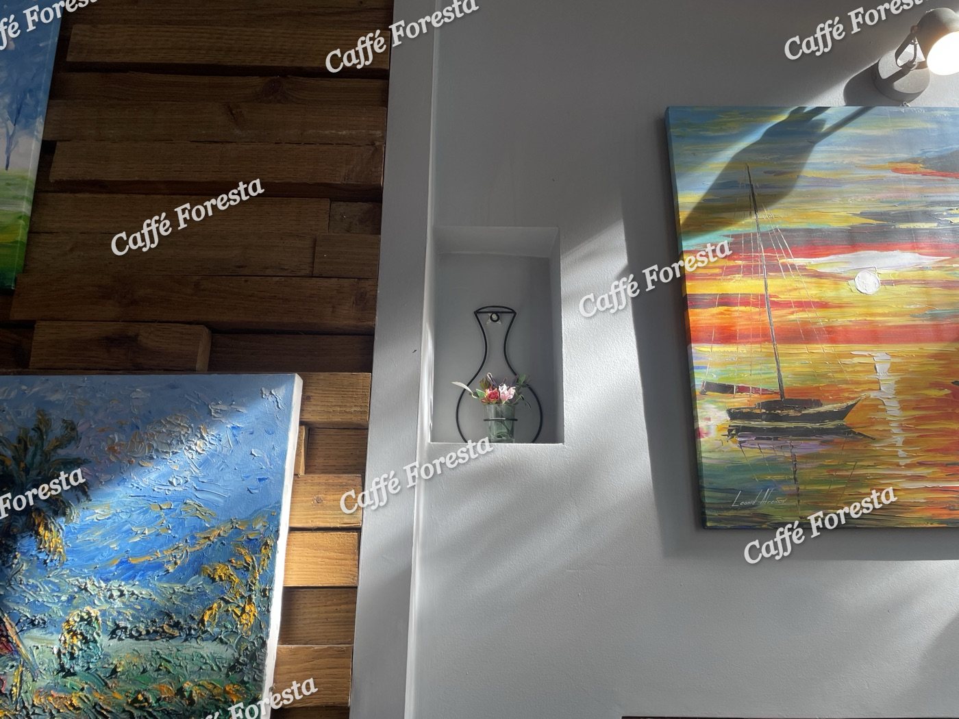 Paintings and a small vase on the wall